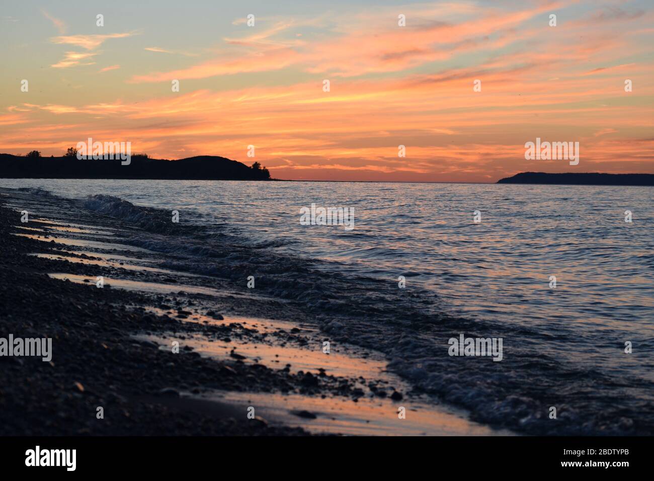 Tramonto a Sleeping Bear Dune Lake Shore nel Michigan settentrionale. Spiaggia di acqua dolce con vista sull'isola sulla destra. Foto Stock
