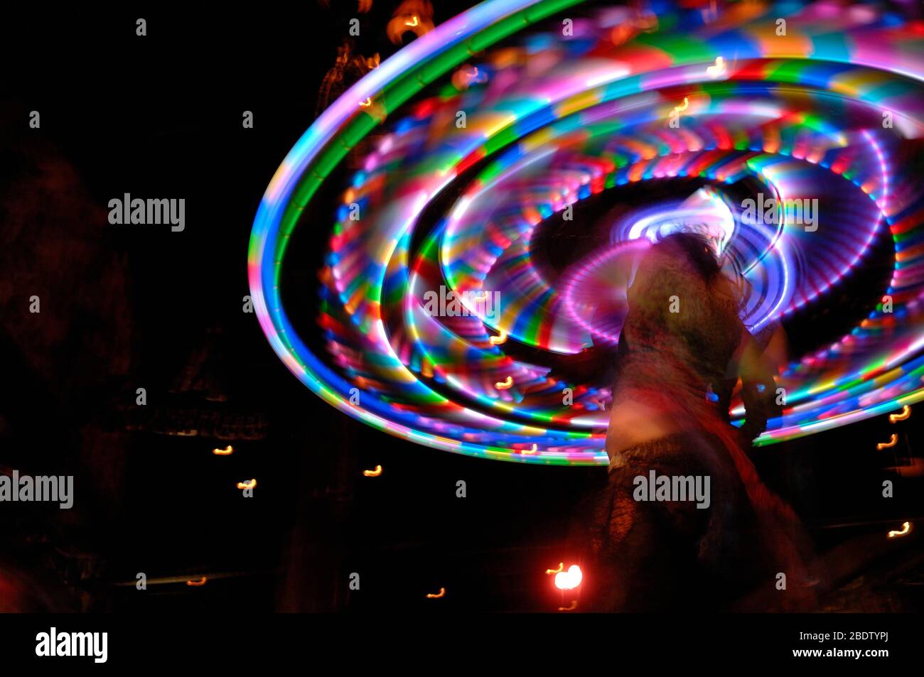 Luci multicolore Hula Hoop tortuate in Circular Motion da Dancer in Lace con Slow Shutter Speed causando la fotografia intenzionale di sfocatura Foto Stock