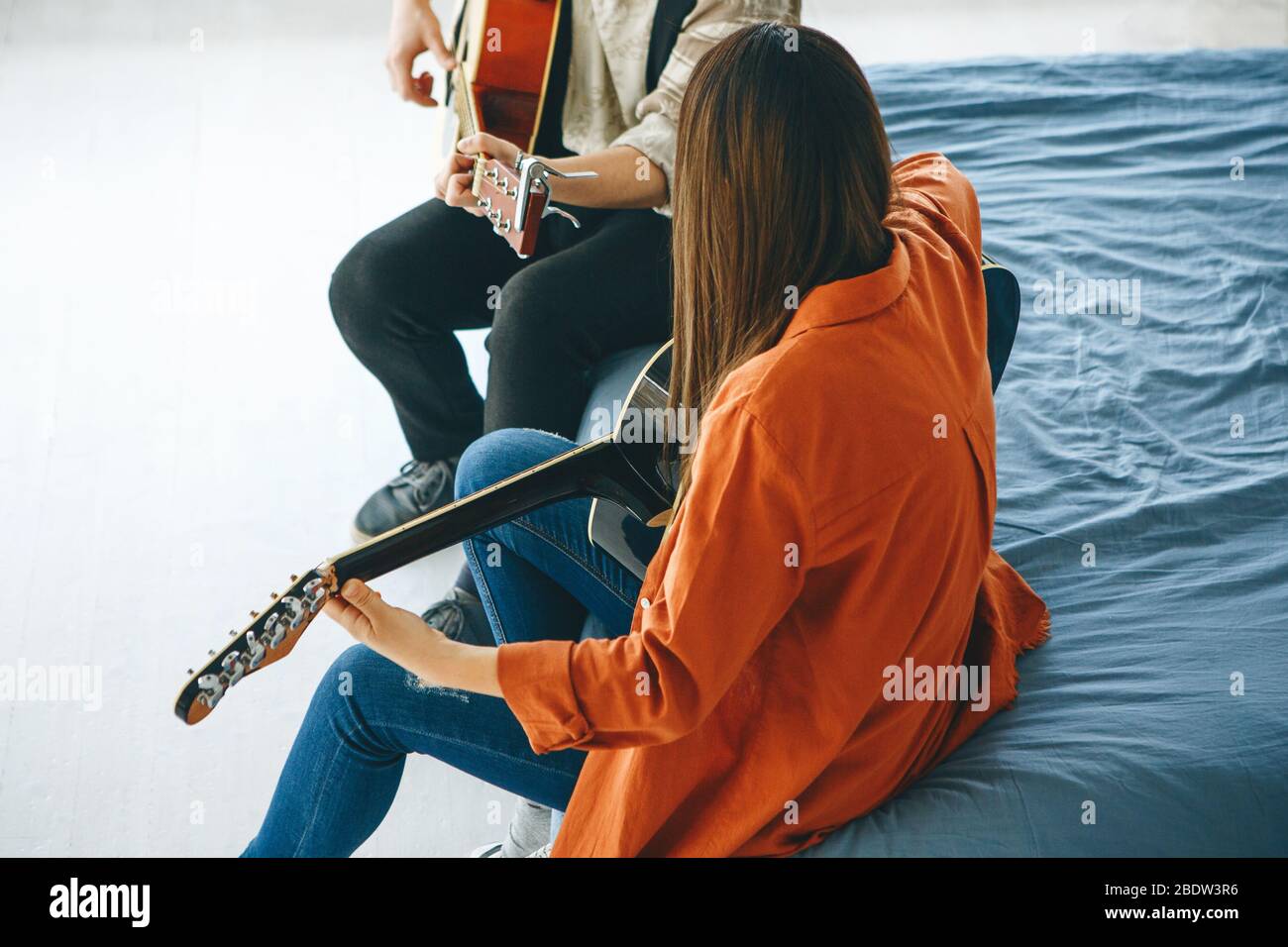 Imparare a suonare la chitarra. L'insegnante spiega allo studente le basi per suonare la chitarra. Lezioni individuali di scuola domestica o extracurricolare. Foto Stock