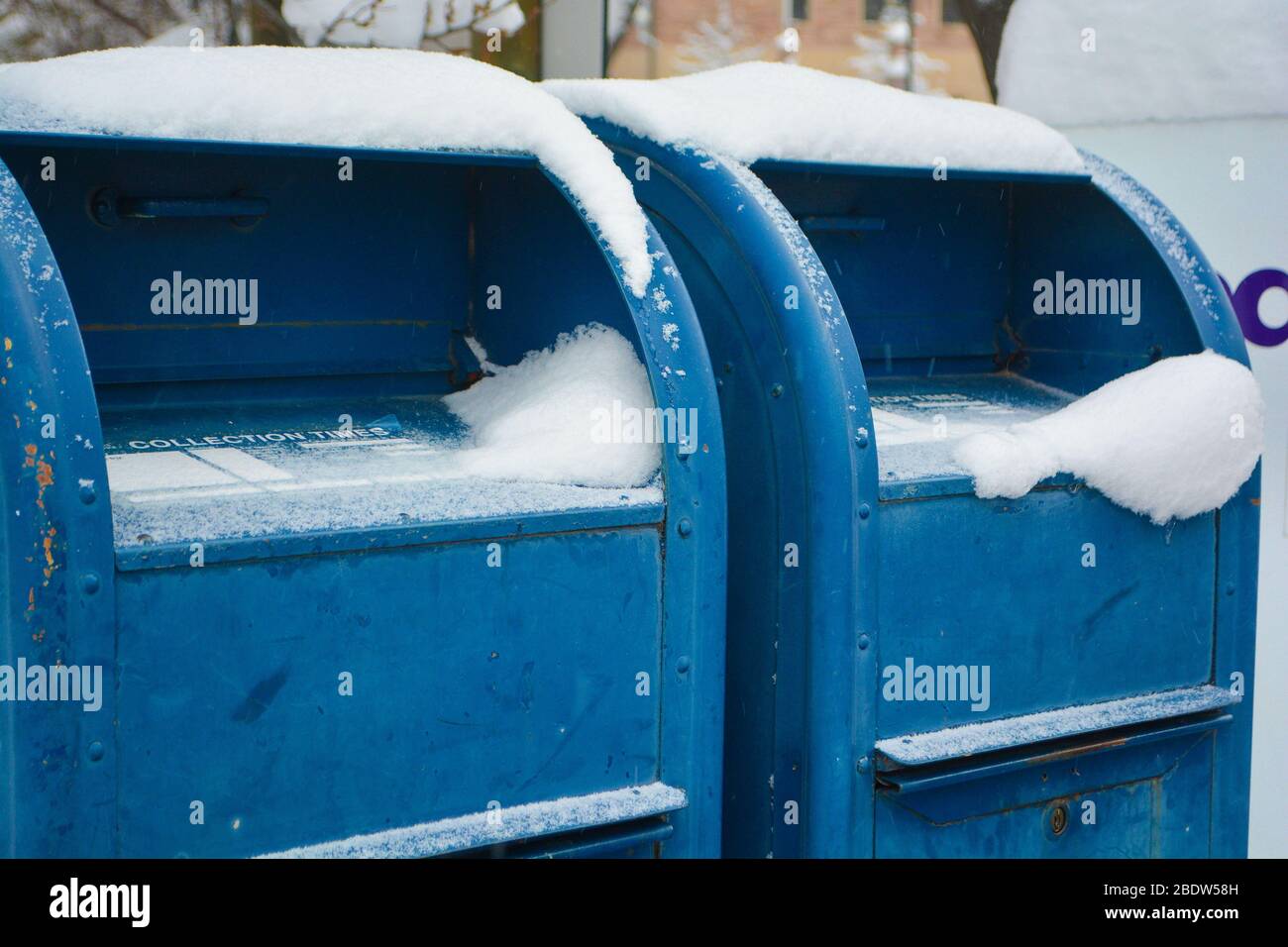 Caselle di posta blu con neve su di loro Foto Stock