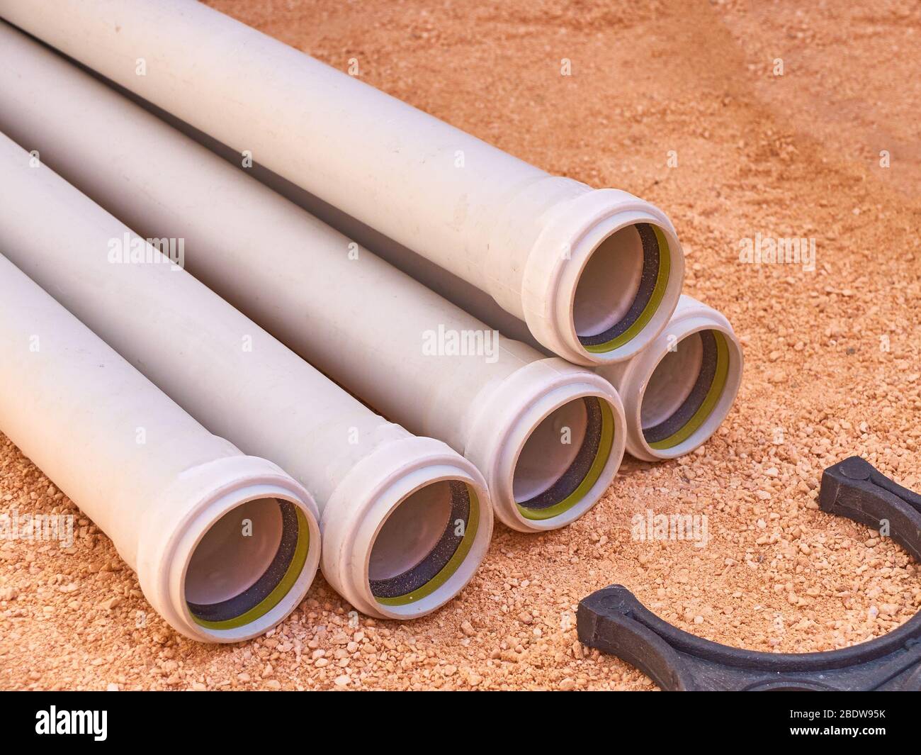 Parti in plastica del sistema di tubazioni di scarico nel cantiere. Foto Stock
