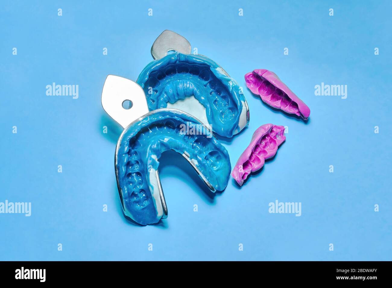 Due impressioni dentali su sfondo bianco e blu. L'impronta della fila di denti di pezzi di registrazione ad alta precisione e morso Foto Stock