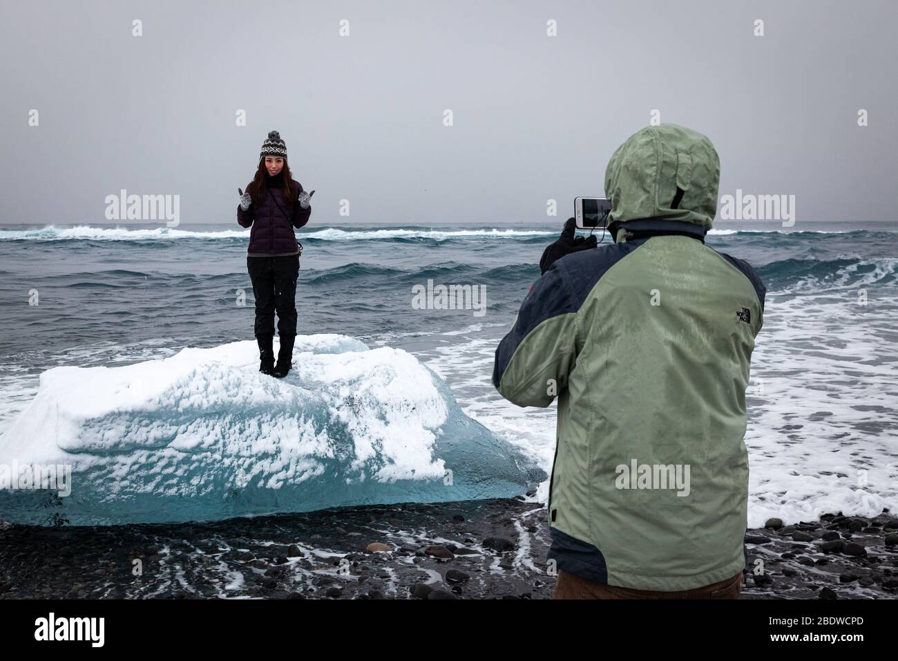 Ritratto di una donna che posa su un piccolo iceberg in Islanda Foto Stock