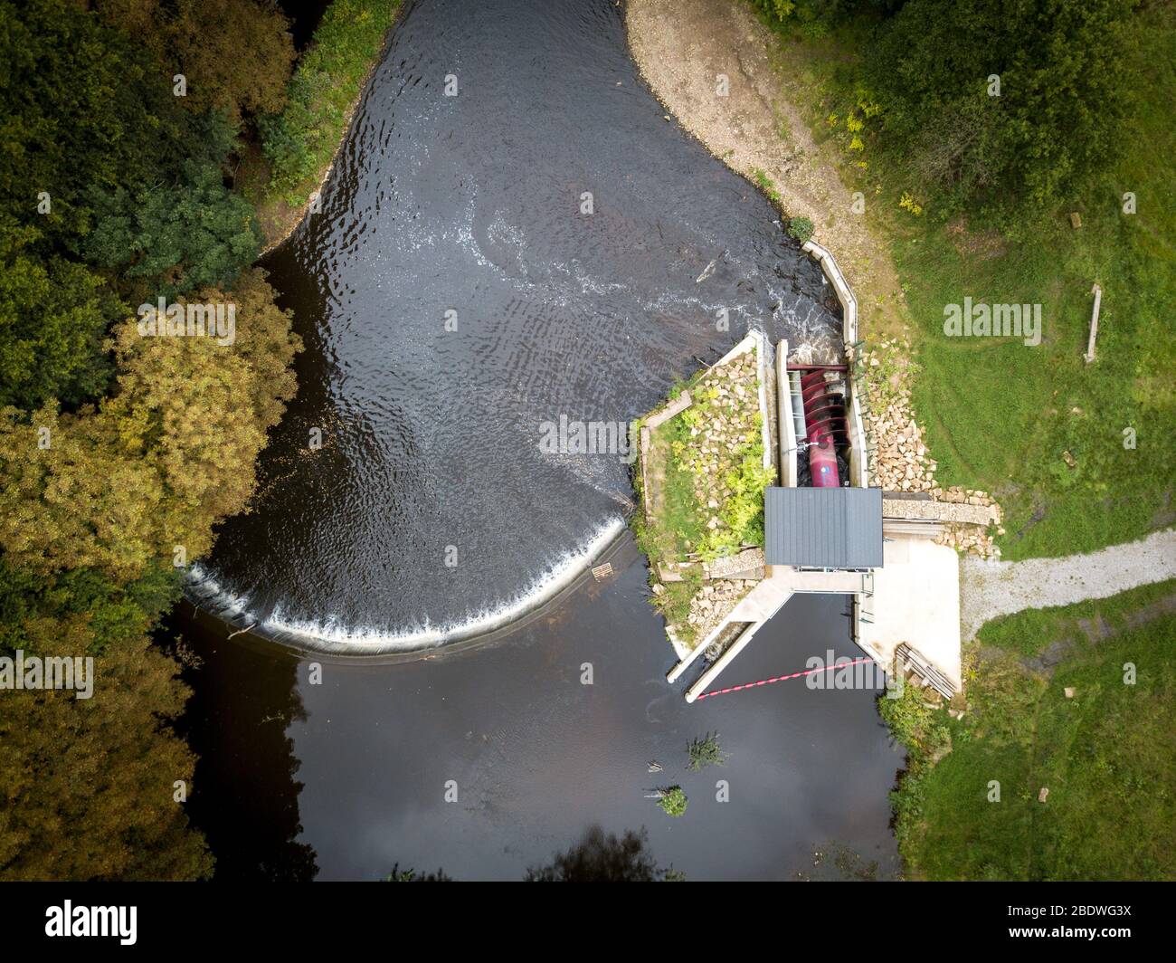 Un sistema di idroalimentazione a testa bassa a vite di Archimedes installato da Hallidays Hydropower per alimentare un edificio di mulino riutilizzato a Manchester, Regno Unito Foto Stock