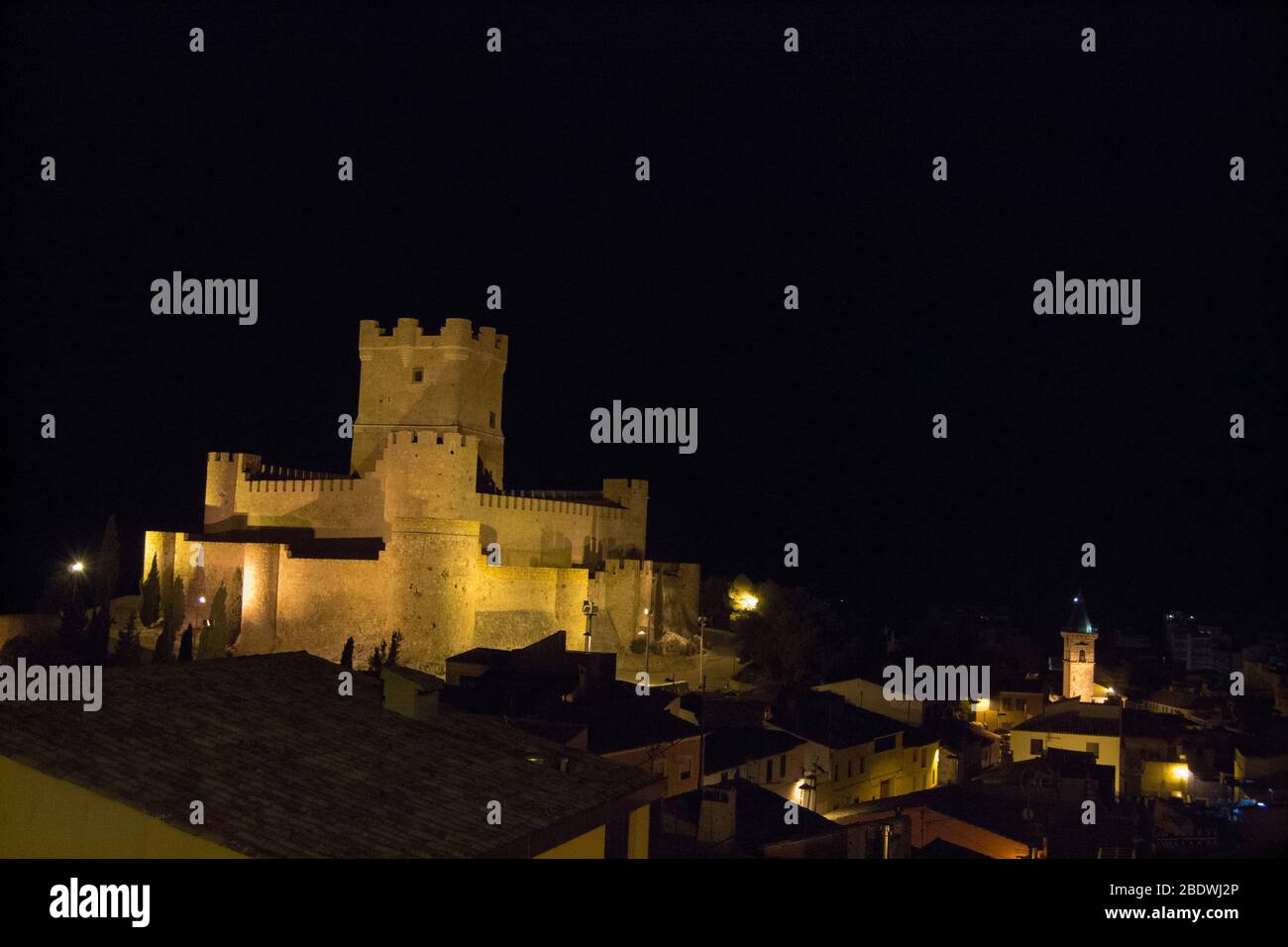 Castello medievale illuminato sopra l'antica città di notte. Castello di Atalaya, Villena, Spagna. Foto Stock