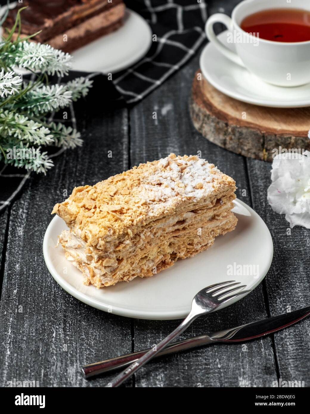 torta napoleonica con tè nero sul tavolo Foto Stock