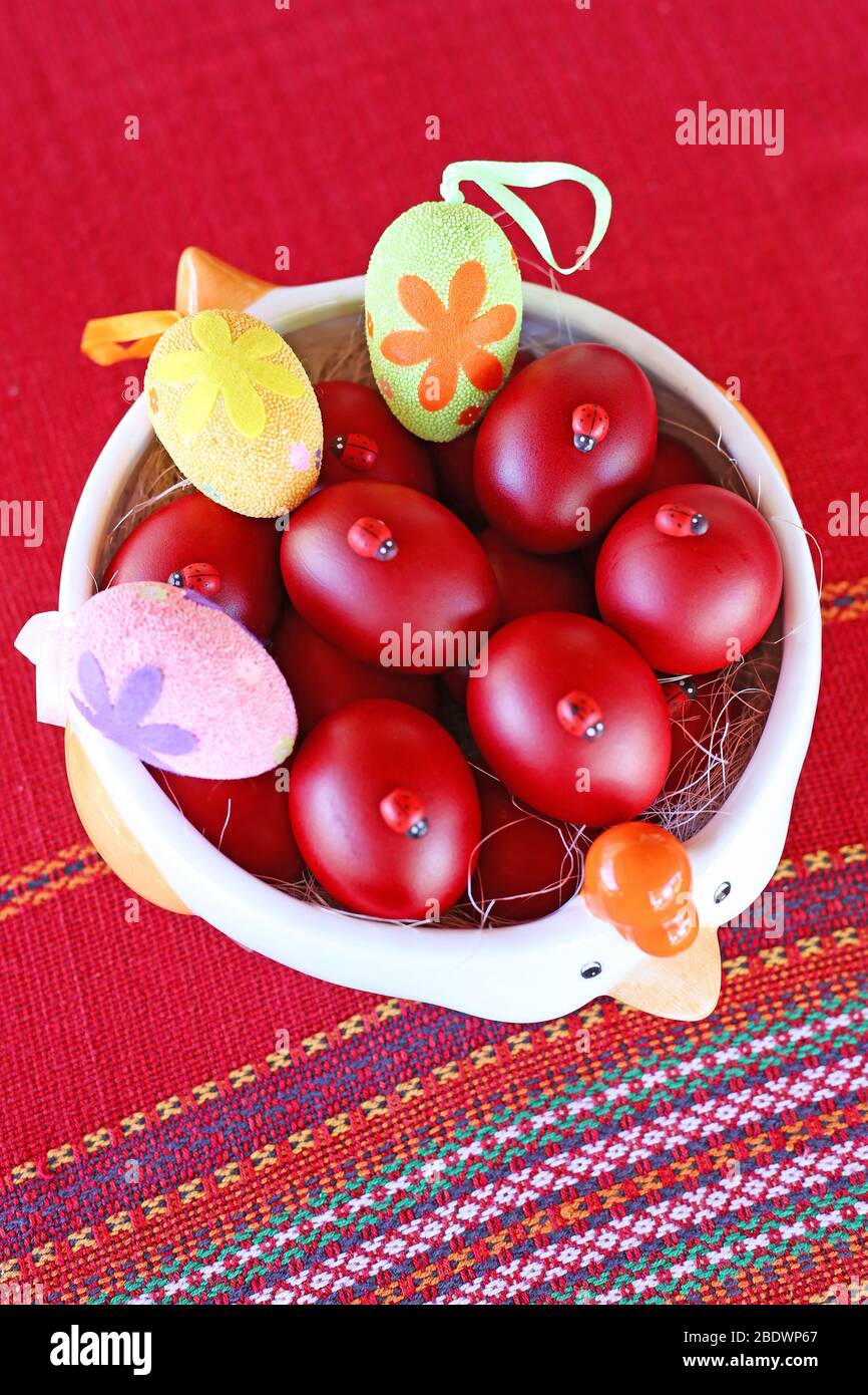 Piatto pieno di uova di Pasqua rosse sul tavolo Foto Stock