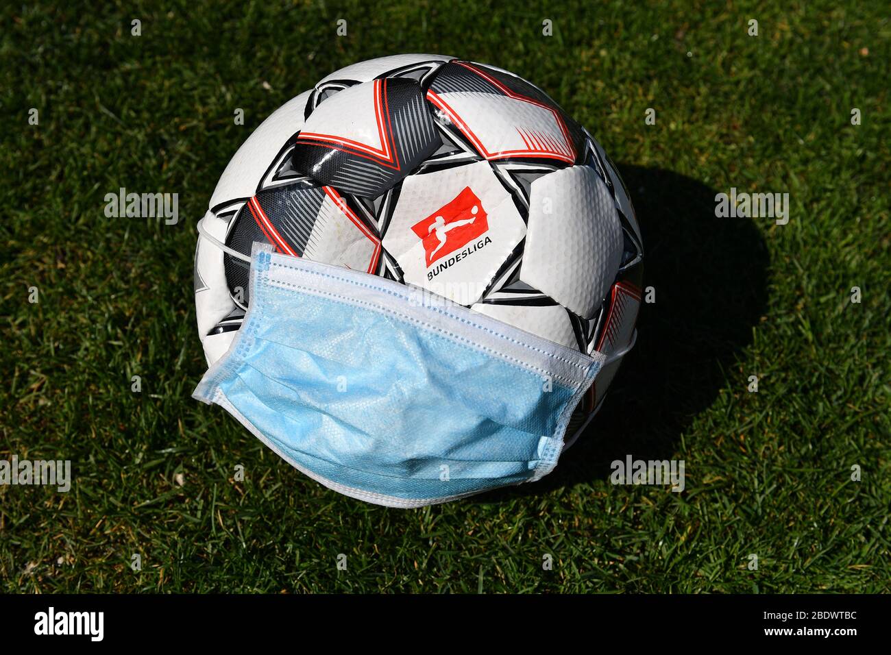 Tema foto: Seguire la corona pandemic su sport professionali e le leghe di calcio. E 'completamente aperto come si può camminare con il calcio e quando e se può essere giocato di nuovo a tutti. Ora il pnat DFL una continuazione delle operazioni di gioco dal 9 maggio 2020. Logo della Bundesliga sulla palla ufficiale Derbystar. La palla indossa una maschera protettiva, una maschera facciale, una maschera facciale. Calcio 1. Bundesliga. | utilizzo in tutto il mondo Foto Stock