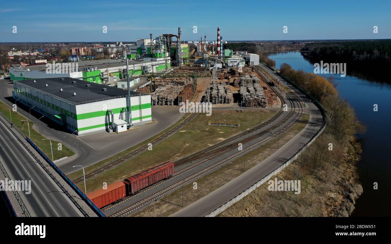 tubi di legno impresa segheria pianta vicino fiume. Concetto di inquinamento dell'aria. Paesaggio industriale inquinamento ambientale spreco di energia termica p Foto Stock