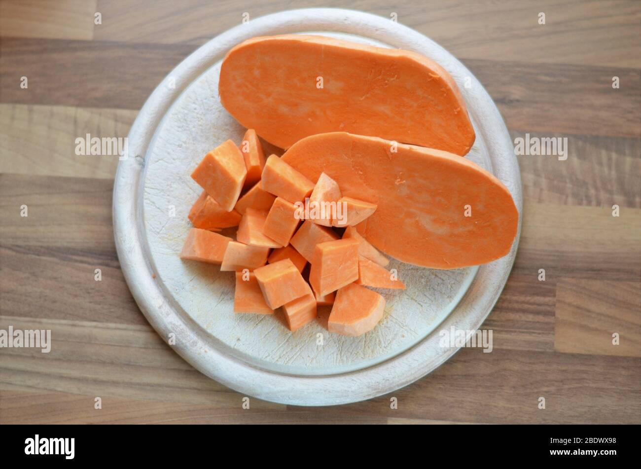 potatoe dolce a dadini su un tagliere su un tavolo di legno Foto Stock