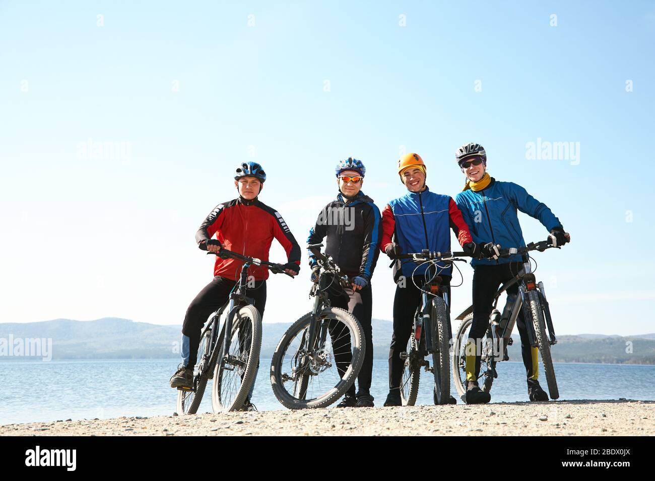 gruppo di ciclisti sulla riva di un lago di montagna. team all'aperto. mountain bike. Foto Stock