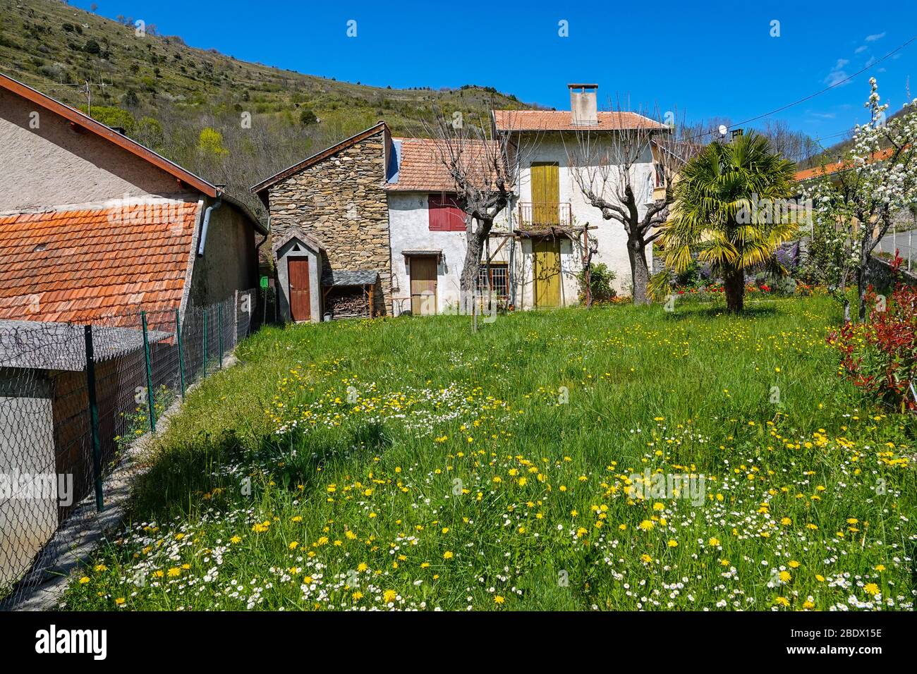 Giardino fiorito e casa con navette, Ornolac Ussat les Bains, Ariege, Pirenei francesi, Francia Foto Stock