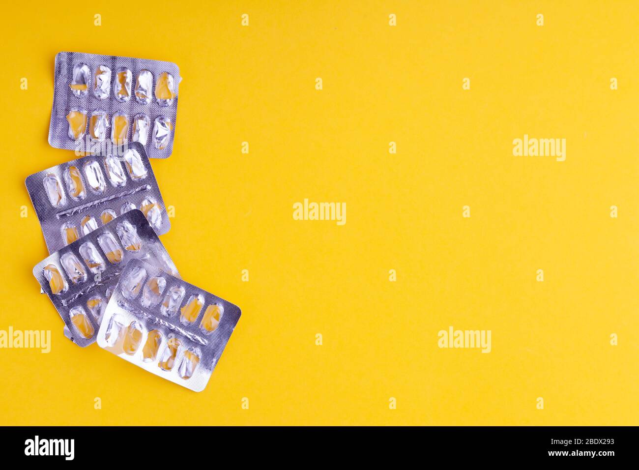 Blister in alluminio argento vuoto, contenitori di vitamine medicinali,  pillole, compresse posto su sfondo giallo, posto per testo, spazio copia,  vista dall'alto Foto stock - Alamy