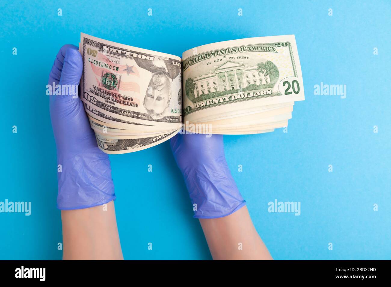 Mani in guanti di lattice medico conta soldi, banconote dollari americani  su sfondo blu, calcolo delle perdite, danni, rovina, debito, depressione a  causa del cor Foto stock - Alamy