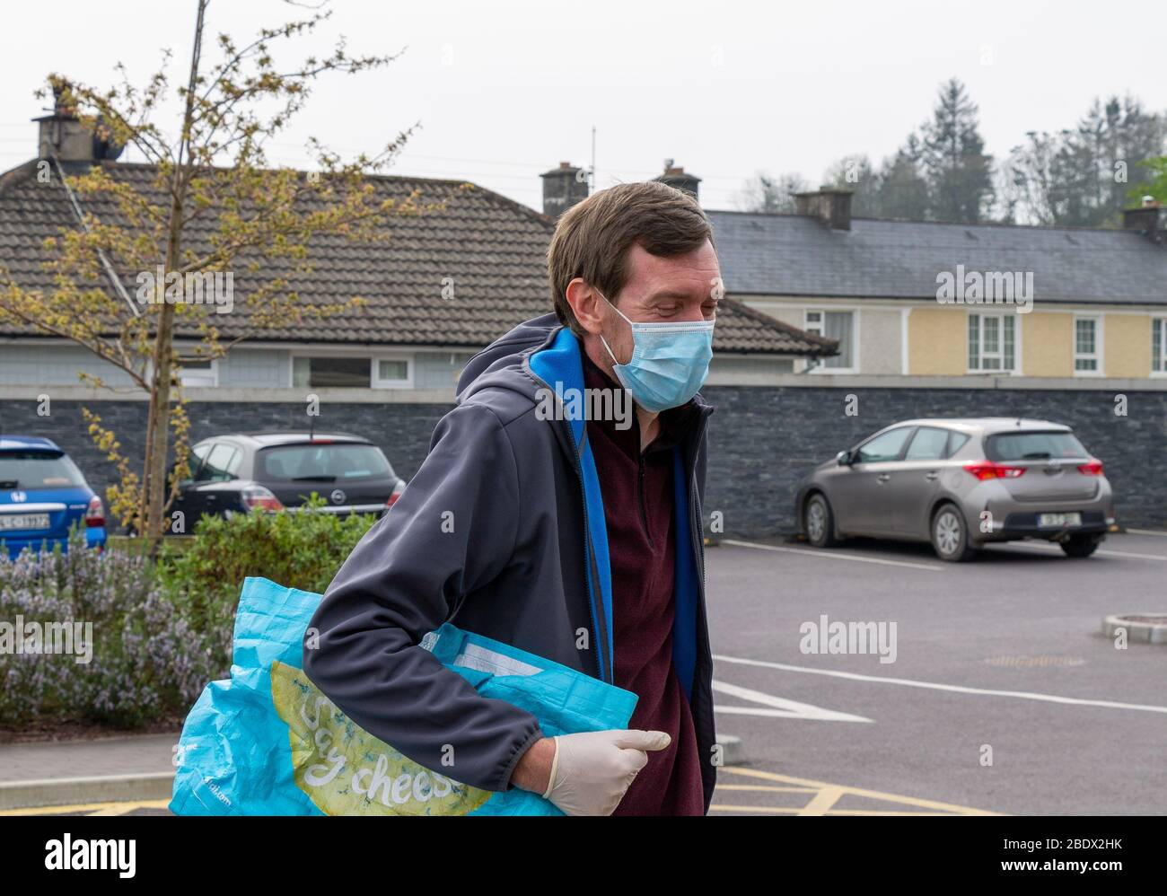 Uomo che indossa una maschera chirurgica del viso durante la Pandemia di Coronavirus Foto Stock