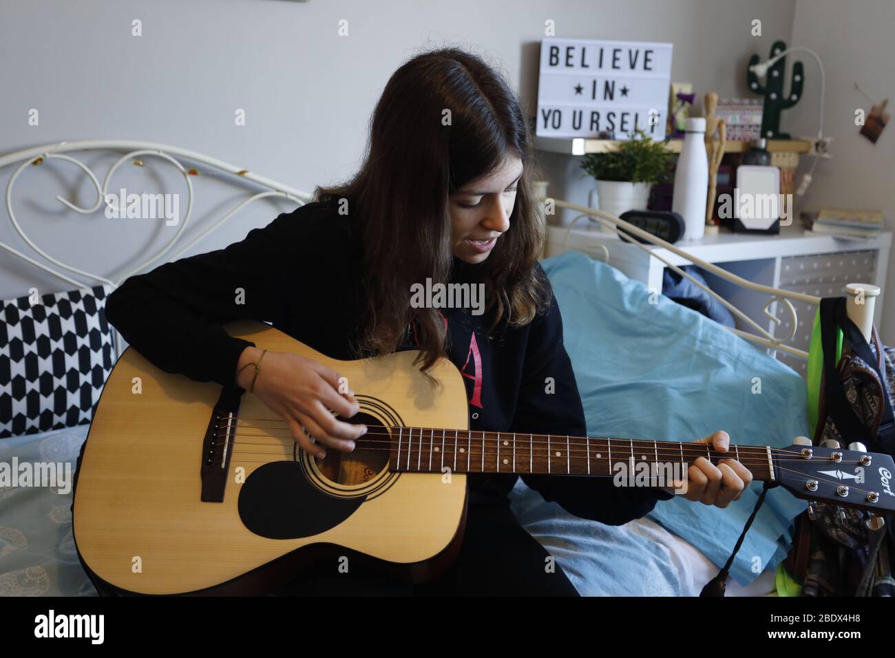 Adolescente che suona la sua chitarra nella sua stanza durante il blocco Covid19 in Catalogna, Spagna Foto Stock