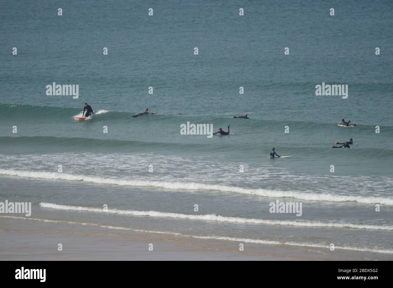 Surfisti in acqua a Fistral Beach a Newquay sulla costa settentrionale della Cornovaglia, mentre il Regno Unito continua a fare il lock-down per contribuire a frenare la diffusione del coronavirus. Foto Stock