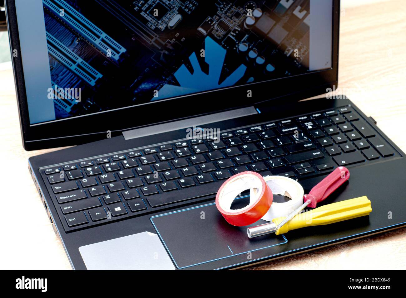 Concetto di lavoro remoto su Internet su un laptop Lie elettrico cacciavite a nastro su un laptop immagine schermo di un quadro elettrico Foto Stock