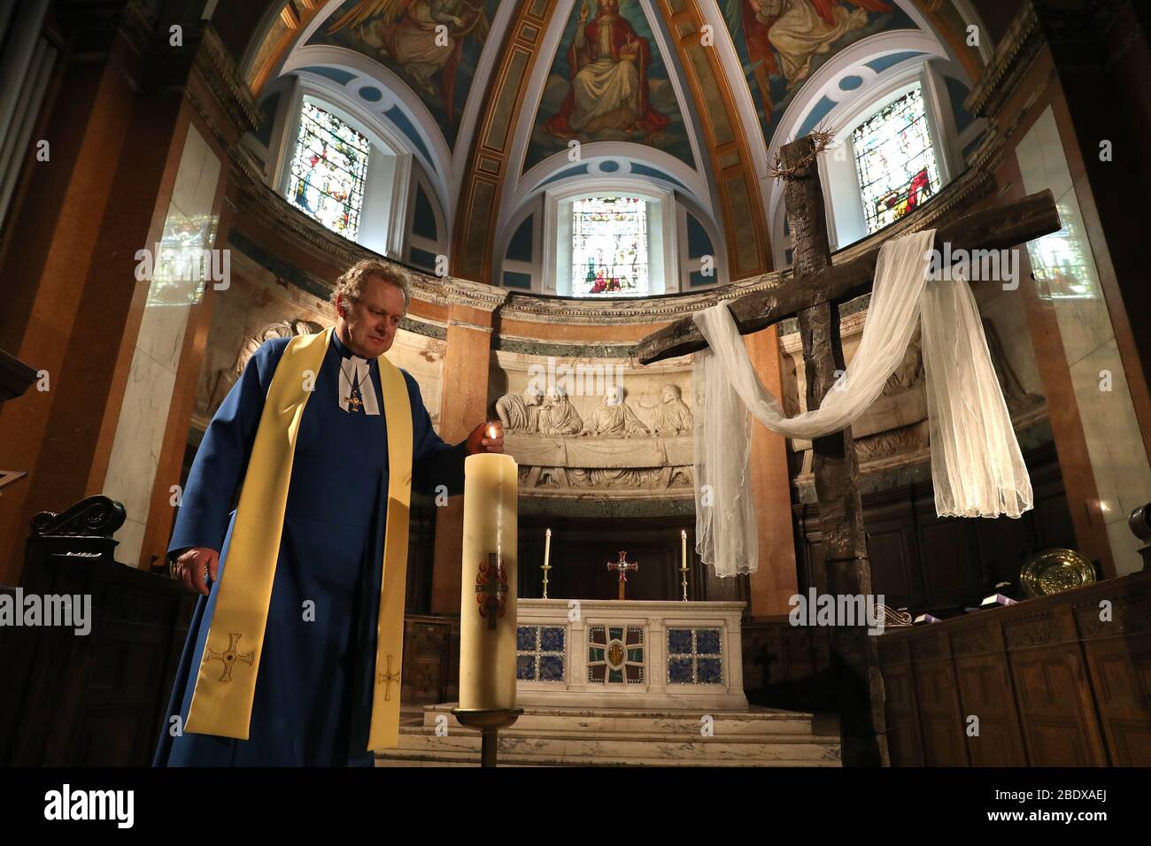 Imbarcato al 0001 Sabato 11 Aprile il Rev. Peter Sutton accende la candela di Pasqua mentre registra il sermone della Domenica di Pasqua nel Santuario principale presso la Chiesa Parrocchiale di St Cuthbert a Edimburgo, La chiesa è stato streaming sermoni come il Regno Unito continua in blocco per contribuire a frenare la diffusione del coronavirus. Foto Stock