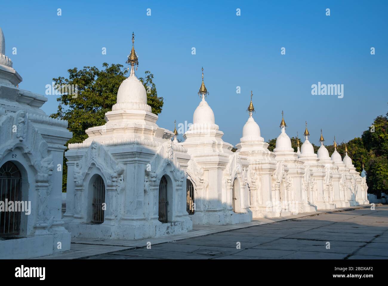 Stupa bianco ornato alla Pagoda di Kuthodaw, Mandalay, Myanmar con sfondo blu cielo Foto Stock