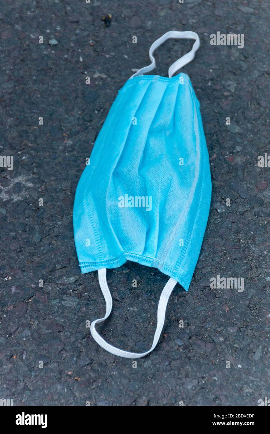 Una vista ravvicinata di una maschera facciale monouso scartata a causa dell'epidemia di coronavirus-COVID 19 Foto Stock