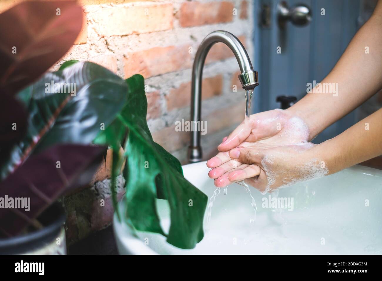 Sciacquare le mani sotto l'acqua corrente. Lavando le mani è il senso più efficace impedire la diffusione dei germi. Foto Stock