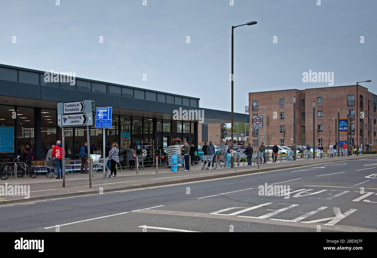 Portobello High Street, Edimburgo, Scozia, Regno Unito. 10 aprile 2020. Nella foto: 24 carrelli visibili con persone che si accodano al supermercato Aldi il Venerdì Santo. Foto Stock