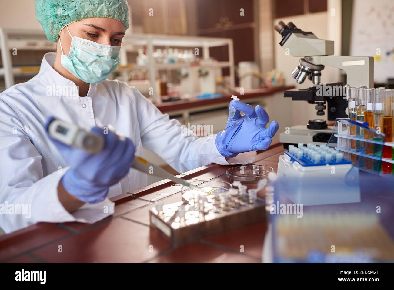 Lavoratrice di laboratorio con attrezzature protettive in laboratorio Foto Stock