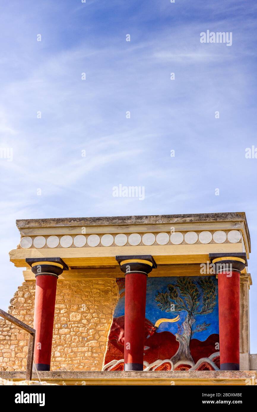 Il Palazzo Minoico di Cnosso con le sue colonne caratteristiche e un affresco di una bolla alle spalle. Creta, Grecia. Foto Stock