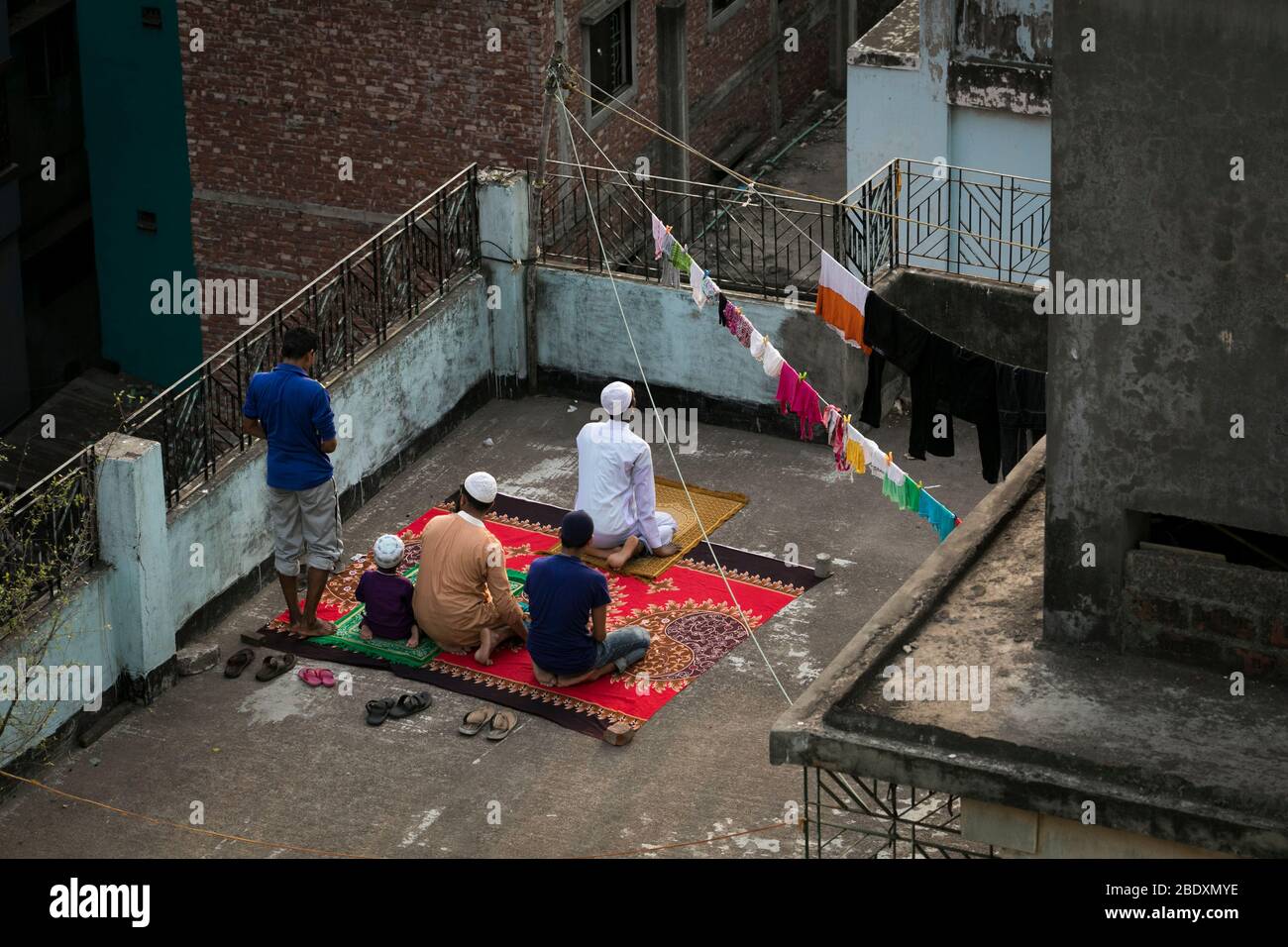 DHAKA, BANGLADESH - APRILE 10: I musulmani del Bangladesh pregano la loro preghiera sul tetto di un edificio durante la chiusura imposta dal governo come un preventivo me Foto Stock