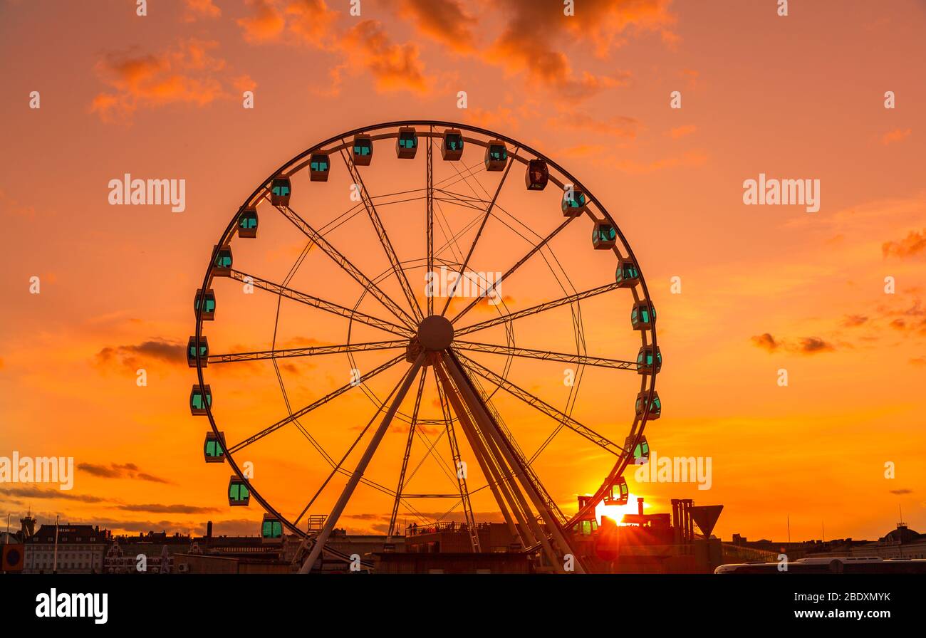 Ruota panoramica al tramonto, cielo colorato e ruota panoramica. Foto Stock