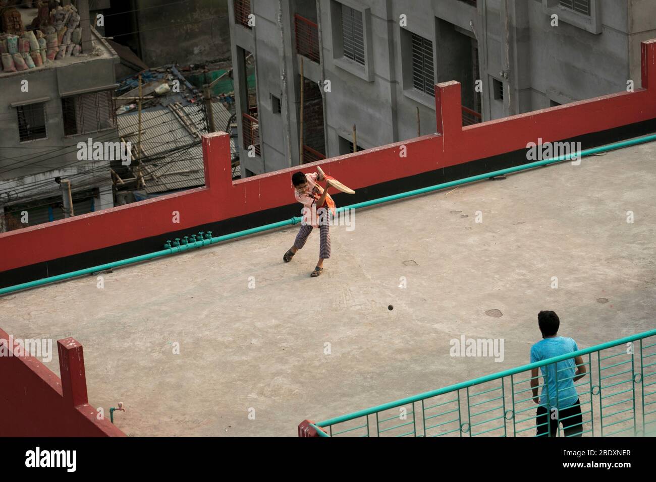 DHAKA, BANGLADESH - APRILE 10: Bambini che giocano a cricket sul tetto di un edificio durante la chiusura a chiave imposta dal governo come misura preventiva contro Foto Stock