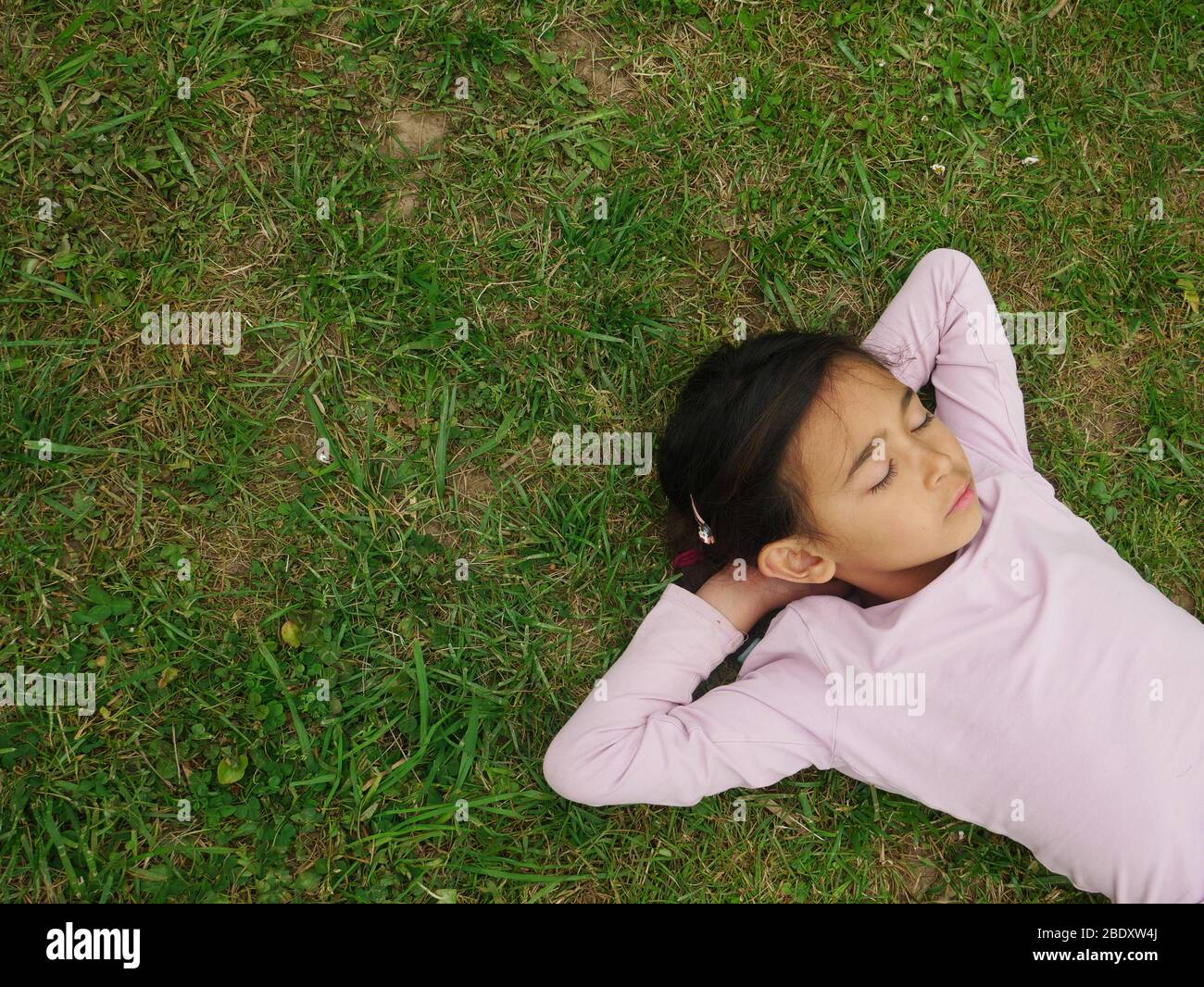 Bambina che dorme sull'erba Foto Stock