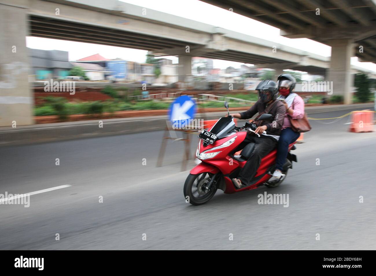 Giacarta, Indonesia. 10 aprile 2020. I motociclisti privati possono ancora viaggiare insieme ai passeggeri, sia il conducente che il passeggero devono indossare maschere e guanti, durante l'attuazione delle restrizioni sociali su larga scala (PSBB) nella regione della capitale speciale di Giacarta. Mentre il trasporto a due ruote basato su applicazione è limitato all'uso consentito solo per il trasporto di merci. (Foto di Kuncoro Widyo Rumpoko/Pacific Press) Credit: Pacific Press Agency/Alamy Live News Foto Stock