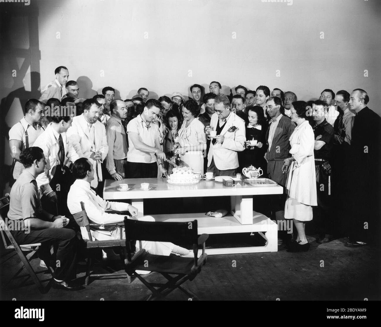 Cast and Crew, incluso THOMAS MITCHELL, assistente regista WINGATE SMITH (con baffi) MARY ASTOR e JOHN FORD festeggiano il compleanno di un membro della squadra sul candid del set durante le riprese del regista DELL'URAGANO 1937 JOHN FORD romanzo Charles Nordhoff e James Norman Hall effetti speciali James Basevi The Samuel Goldwyn Company / United Artists Foto Stock