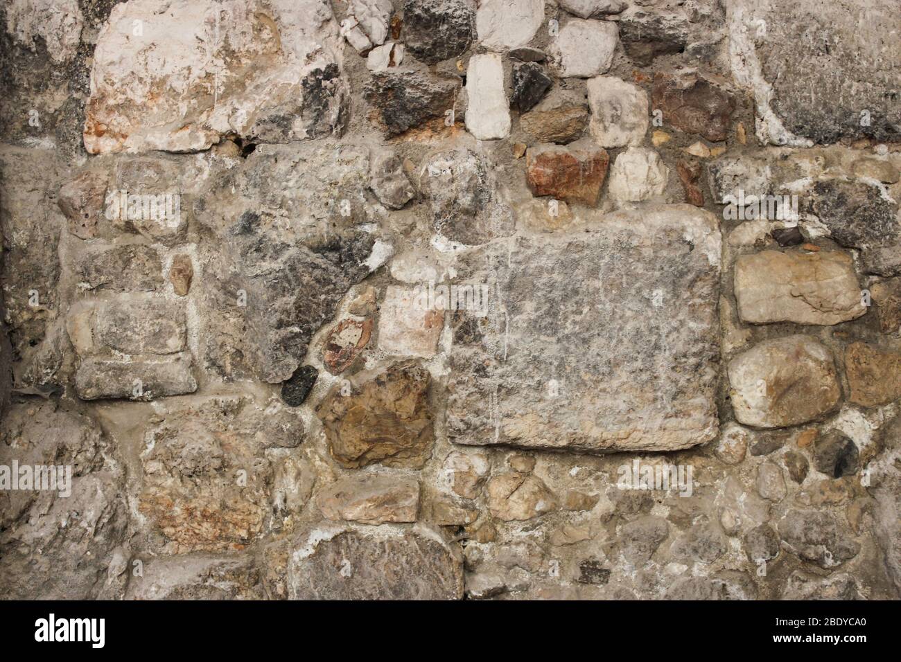 Muratura vecchia da pietre di dimensioni diverse come sfondo Foto Stock