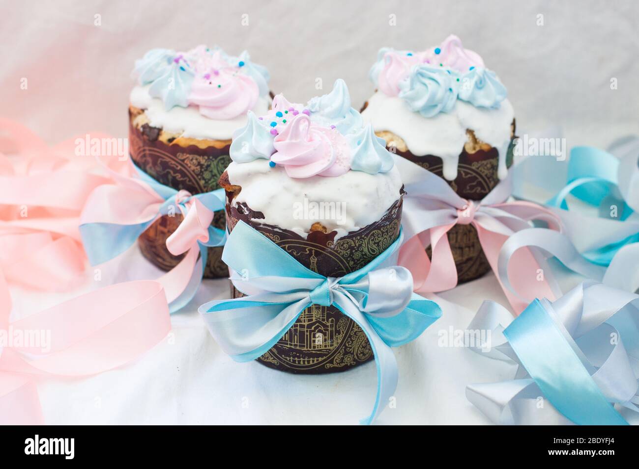 Il kulich del pane di pasqua russo è decorato nei colori pastello delicati rosa e blu. Sfondo bianco. Foto Stock