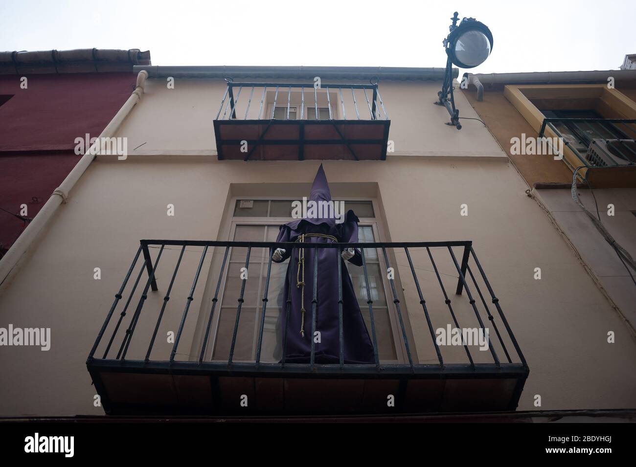 Un manequinn raffigurante un nazareno è raffigurato fuori da un balcone nel centro di Malaga. La tradizionale celebrazione di Pasqua è stata cancellata in Spagna. I credenti vivono nelle loro case una settimana Santa insolita, per questo motivo molte persone decorano i loro balconi con immagini di Cristo e della Vergine Maria. Dopo lo stato di allarme e il blocco nel paese da parte del coronavirus COVID-19, tutte le persone sono racchiuse nelle loro case in seguito al confinamento decretato dal governo spagnolo e che sarà prorogato fino al 10 maggio. Foto Stock