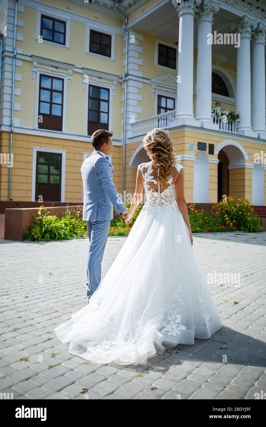 Giovane ragazzo elegante in un vestito lo sposo e la sposa bella ragazza in  un vestito bianco con una passeggiata in treno nel parco il giorno del loro  matrimonio Foto stock -