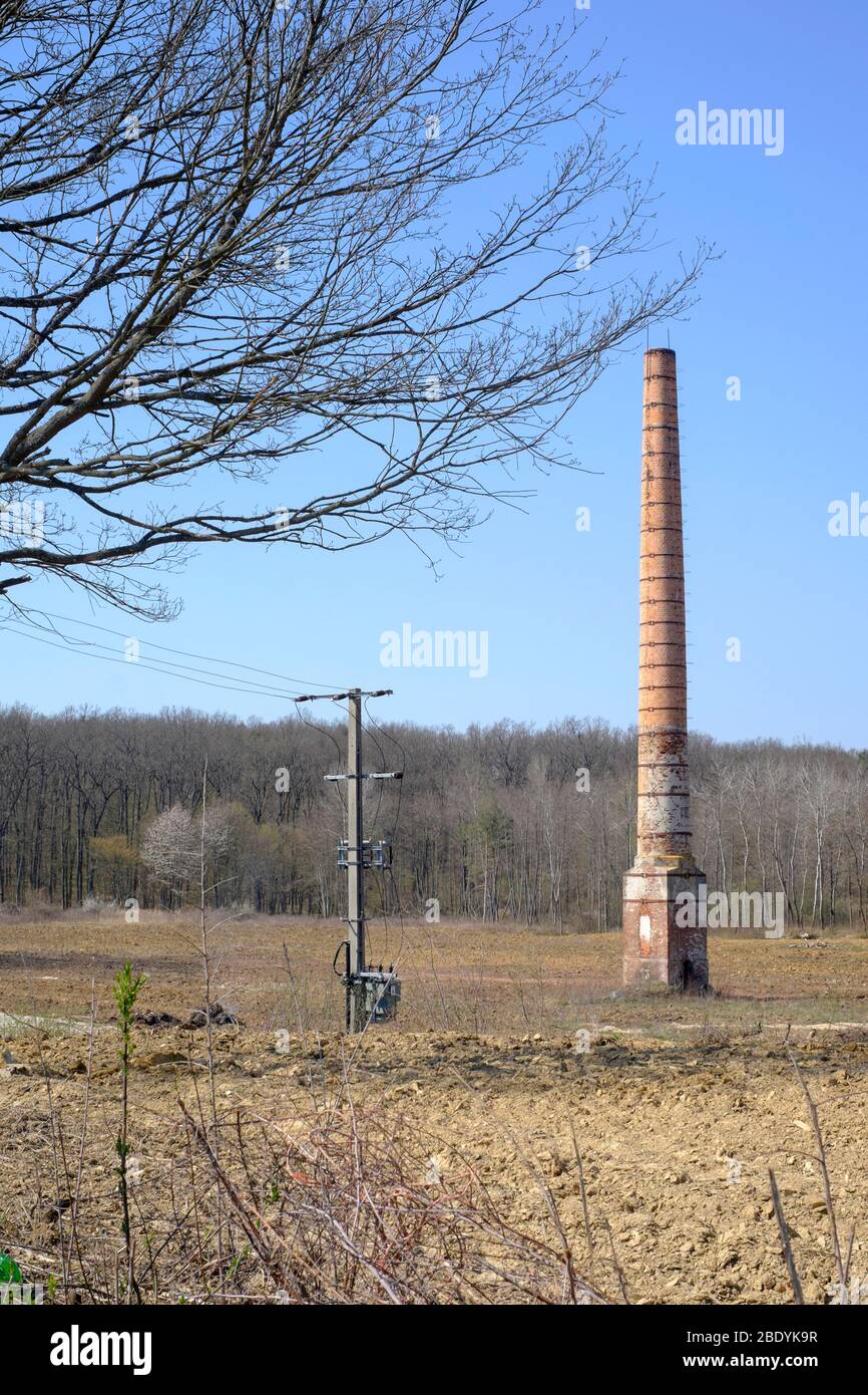 alto camino industriale si trova solo nel centro di un vuoto deserto solitario residuo della precedente fabbrica zala contea ungheria Foto Stock