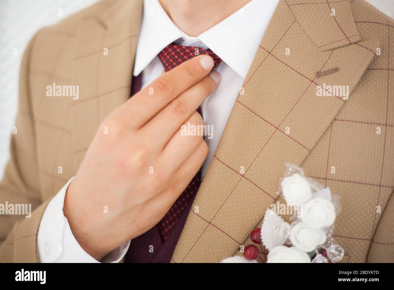 Mani dell'uomo tocca bow tie-in su una tuta Foto Stock