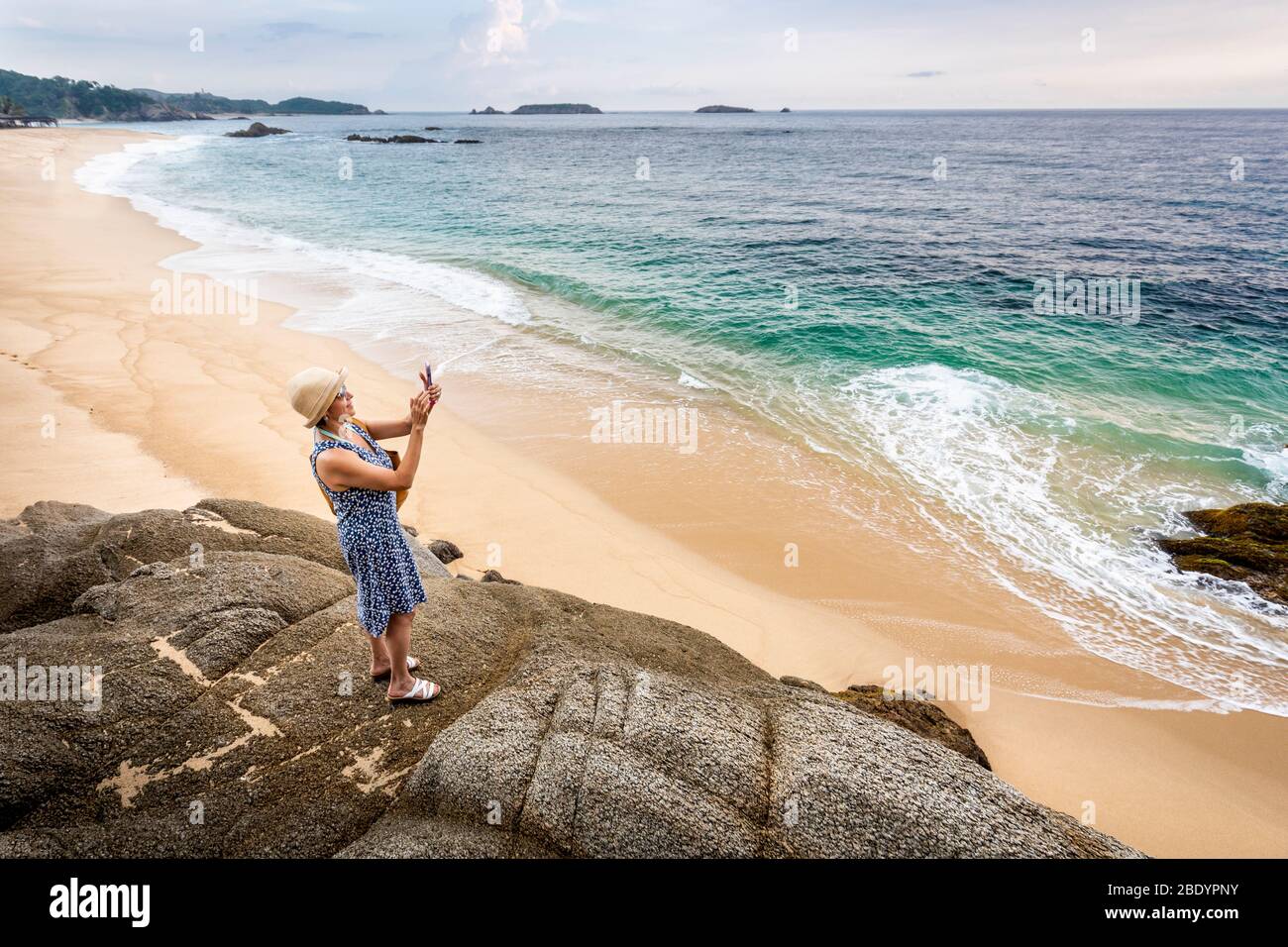 Una donna fotografa la spiaggia di Palma sola sulla costa pacifica del Messico. Foto Stock