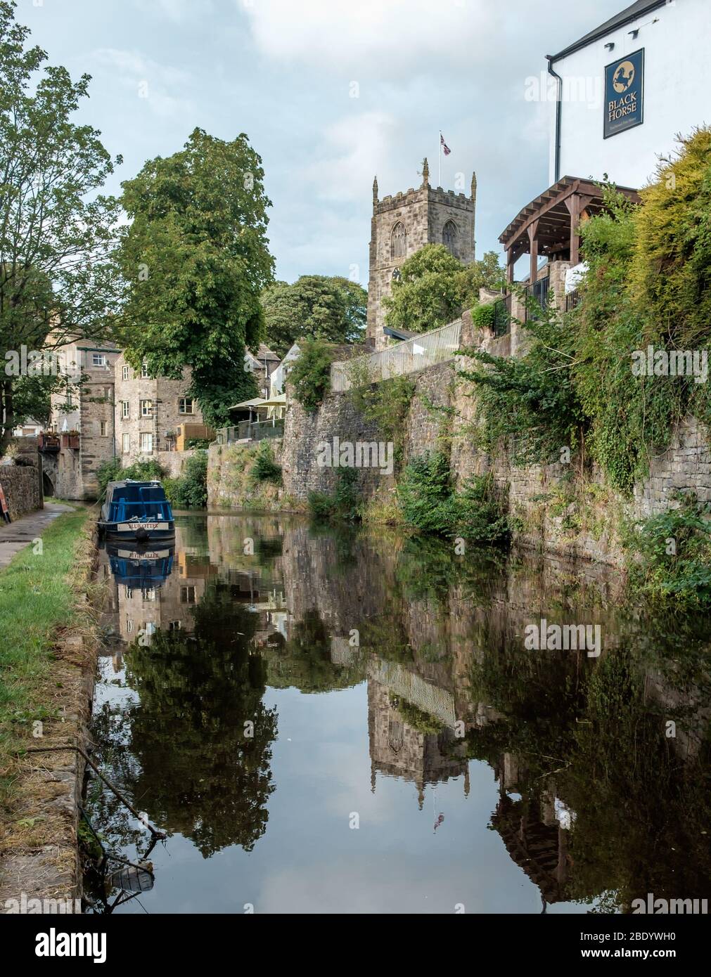 Narrowboats sul canale Thanet a Skipton. Chiesa della Santissima Trinità sullo sfondo Foto Stock