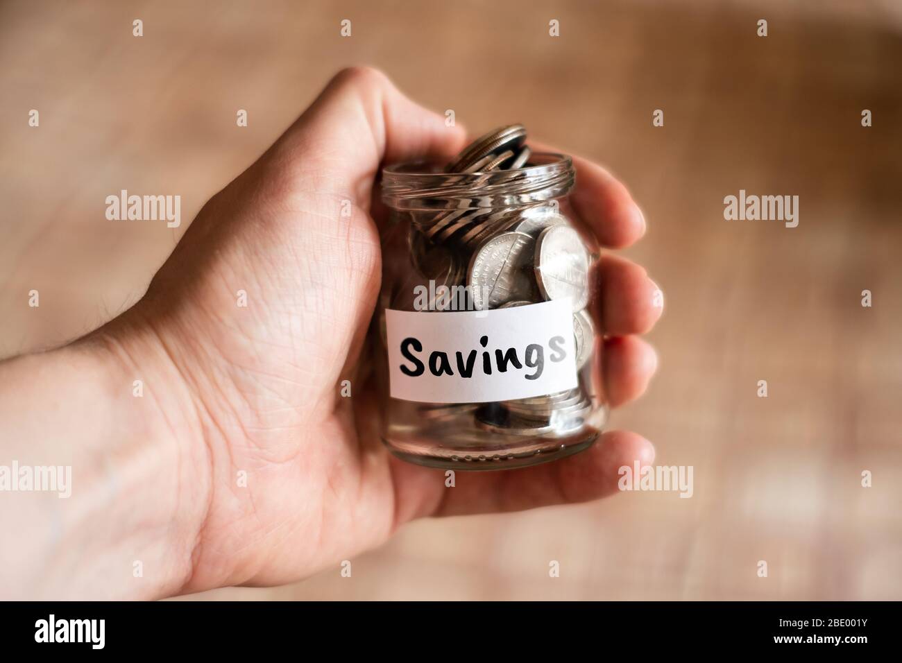 Risparmio di denaro - vaso di vetro con monete. Primo piano. Foto Stock