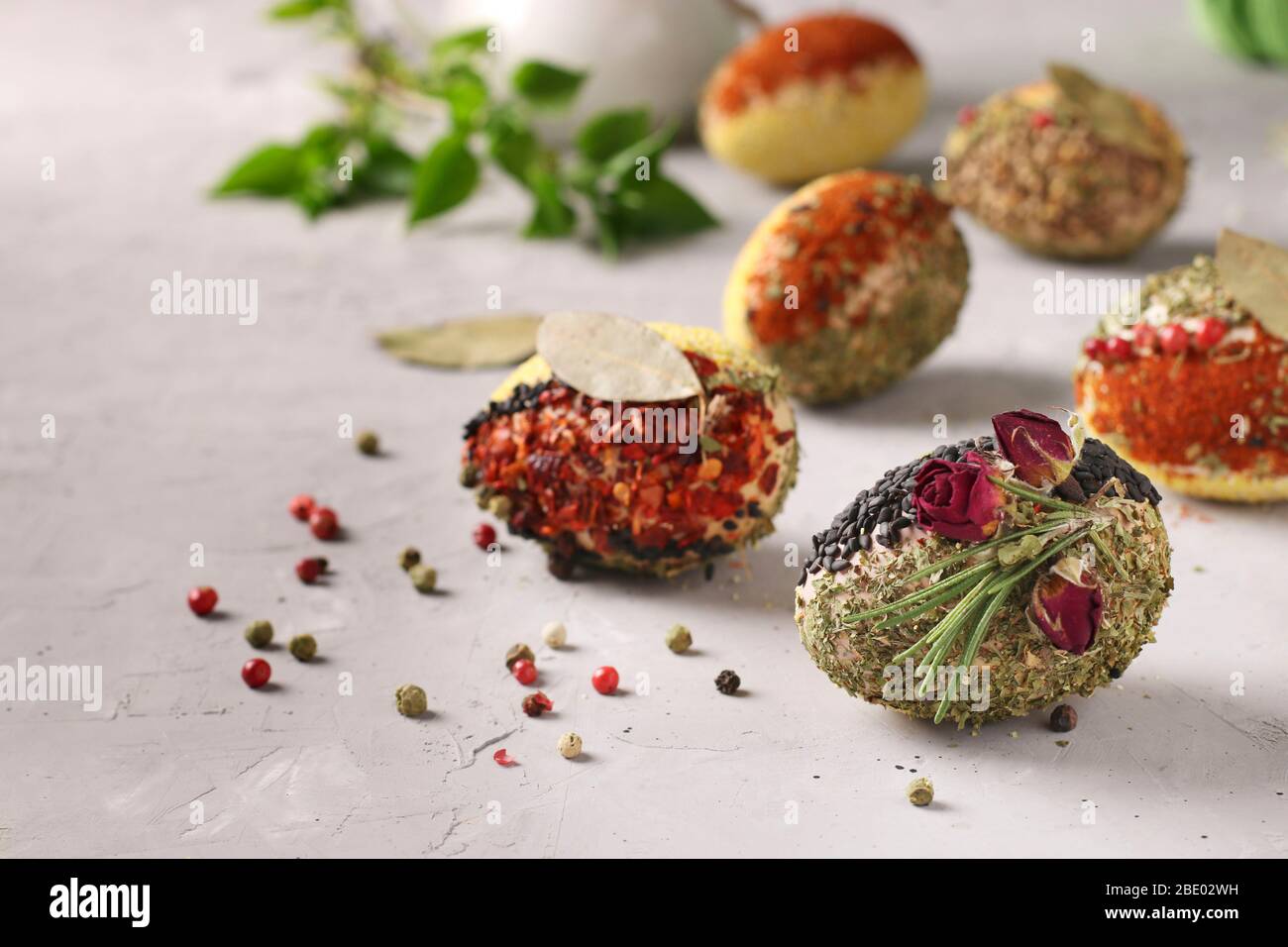 Eco-design delle uova di Pasqua con varie spezie e cereali, senza coloranti e conservanti su fondo grigio cemento, Closeup Foto Stock