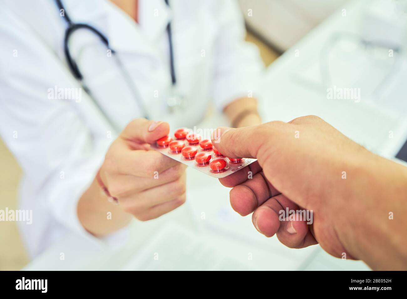 Alla reception e al medico. Il medico ha prescritto il farmaco e sta somministrando il farmaco al paziente della clinica. Farmacologia e. Foto Stock