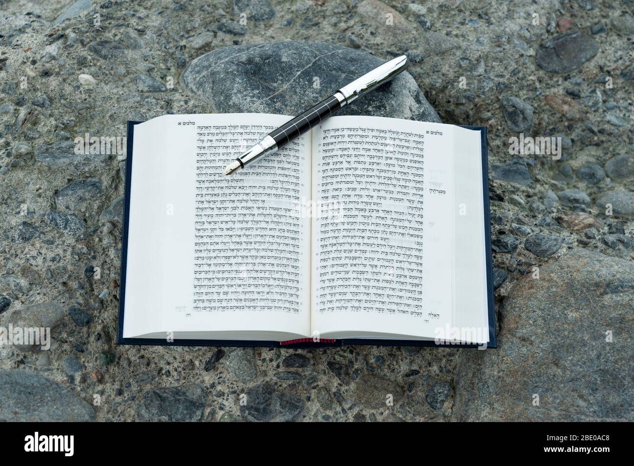 Open Bibbia ebraica - TANAKH (Torah, Nevim, Ketuvim - la Legge, i Profeti, gli scritti) con penna fontana all'aperto. Isolato su pietre sfondo. Foto Stock