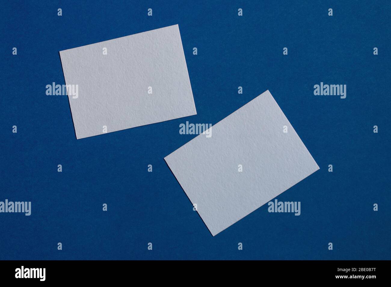 due note adesive bianche su una parete blu Foto Stock