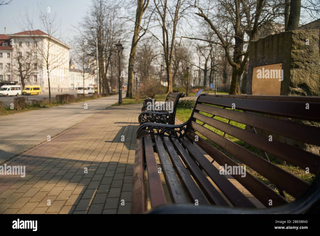panca in legno con gambe in ferro intagliato in ambiente urbano Foto Stock