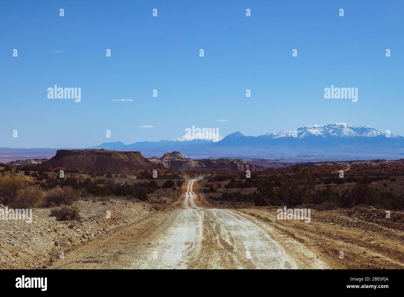 Strade sterrate vuote in Utah con montagne a distanza Foto Stock